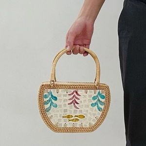 Handwoven rattan shell bag with colorful fish and leaf patterns for beach vacations