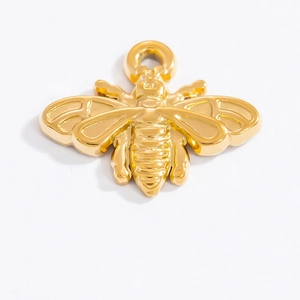 Gros plan d'un pendentif abeille doré poli avec anneau de suspension pour bijoux artisanaux