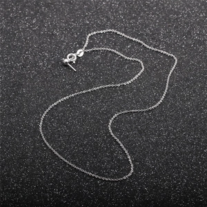 Detailed view of silver necklace chain with spring clasp and extension on black background