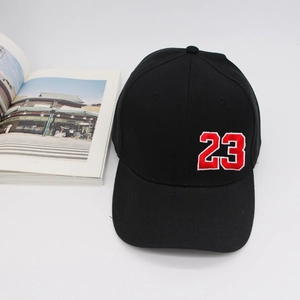 Détail de la casquette de baseball noire en coton avec broderie rouge du numéro 23 sur le côté