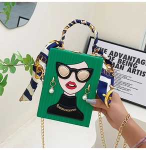 Detail of green graffiti evening bag with cartoon face and silk scarf handle