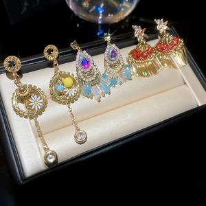 Detailed macro view of fan-shaped tassel earrings and floral motifs on a velvet jewelry tray