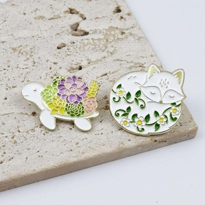 Cute enamel animal pins set featuring a floral turtle and sleeping white fox designs