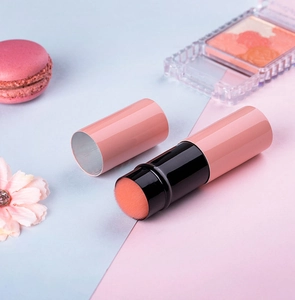 Detailed view of pink retractable blush brush with orange bristles and a black connector