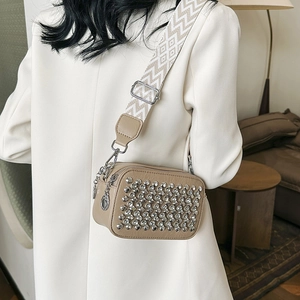 Khaki crossbody camera bag with silver studs and geometric patterned wide strap