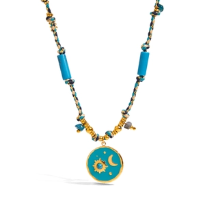 Detailed close-up of 18K gold stainless steel sun and moon pendant on woven cord