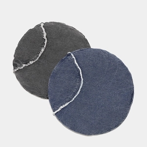 Round denim beret cushions in gray and indigo with decorative white frayed edges