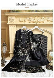 Detail of black floral silk robe and slip dress set hanging by a classic fireplace