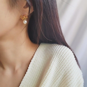 Élégantes boucles d'oreilles nœud en argent 925 avec perle blanche sur mannequin