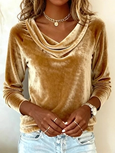 Close-up of golden velvet texture and elegant cowl neck design on a women's long sleeve top