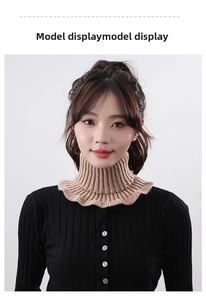Detail of a beige ribbed knit faux collar with ruffled edges worn under a black cardigan