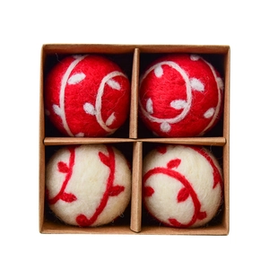 Handmade wool felt Christmas ball ornaments set with red and white leaf patterns in a box