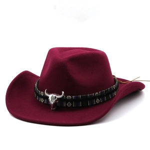 Close-up of dark red wool felt cowboy hat featuring ethnic band and silver bull skull buckle