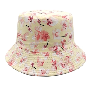Close-up of a cream cotton bucket hat featuring delicate pink floral print details