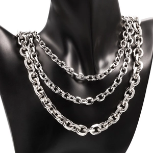 Detailed view of triple-layered silver stainless steel chain necklaces on a black bust