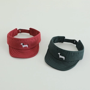 Detail of sun visor hats in red and green with embroidered dachshund dogs and back strap
