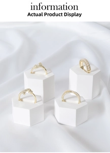 Detailed view of gold bow and pearl rings on white geometric stands and satin