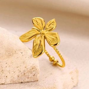 Close-up of golden flower ring with textured petals and twisted rope band details