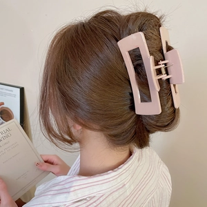 Pink rectangular matte hair claw clip shown styling a chic French twist bun on a model