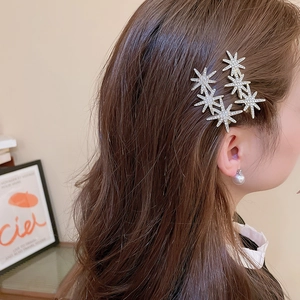 Macro detail of elegant star-shaped hair clips with sparkling crystals on side hair