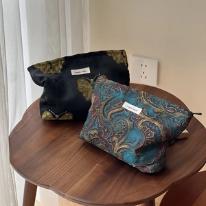 New Chinese-style jacquard makeup bags with butterfly and paisley patterns on wood table