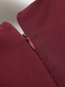 Close-up of a burgundy dress showing the high-quality invisible zipper and fabric texture