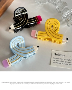 Detailed view of colorful pencil-shaped hair claws in black, yellow and light blue resin