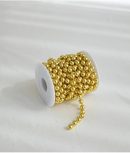 Golden Christmas bead chain spool for festive DIY decorations and tree ornaments