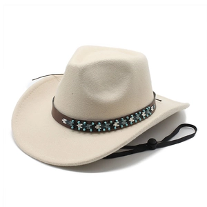 Détail d'un chapeau cowboy crème avec bande en cuir perlée bohème et cordon de serrage