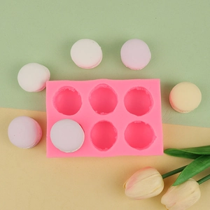 Molde de silicona rosa de 6 cavidades para macarons en fondo colorido con toque de tulipán
