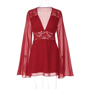 Détail du col en V plongeant et de la dentelle sur une robe rouge à manches évasées
