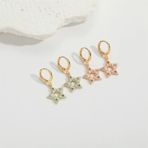 Macro detail of star-shaped enamel hoop earrings in light pink and green with gold plating
