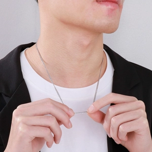 Close-up of a men's silver stainless steel thin chain necklace on a model
