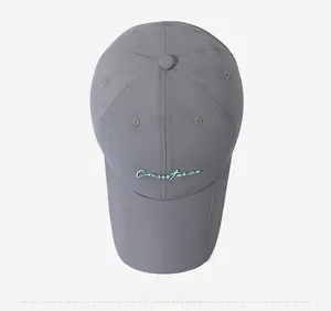 Detailed top view of dark grey quick-dry baseball cap with green letter embroidery
