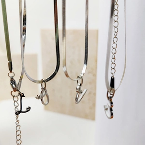 Detail of silver herringbone chains with LOVE letter pendants and lobster clasps
