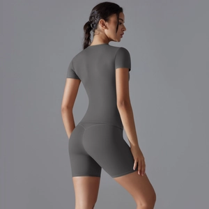 Détail d'un ensemble de yoga gris avec t-shirt de sport moulant et short de vélo gainant