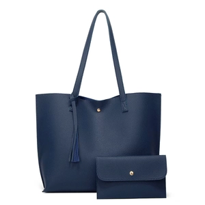 Dark blue pebbled leather tote bag set with tassel and matching pouch on white background
