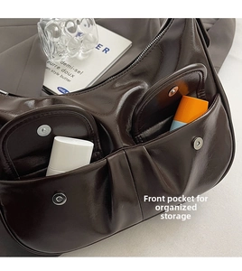 Detail of dark brown glossy leather shoulder bag with two front magnetic pockets
