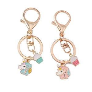 Cartoon unicorn and cupcake keychain charms with golden metal ring on white background