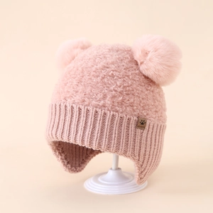 Dettaglio del cappello in maglia rosa per bambini con pompon in ecopelliccia e paraorecchie