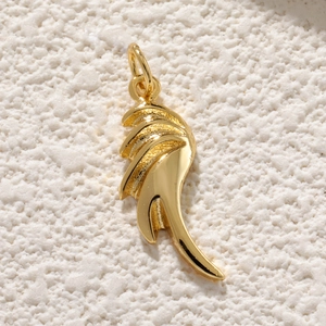 Vue macro du pendentif aile plaqué or avec texture de plumes détaillée et finition polie