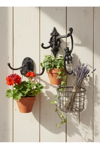 Close-up of vintage black cast iron monkey and decorative triple swivel wall hooks