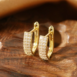 Macro shot of gold hoop earrings with three rows of sparkling pave-set stones