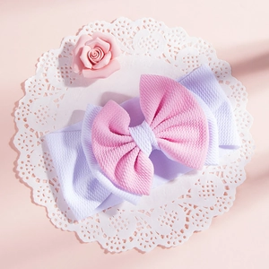 Close-up of baby waffle texture headband with double-layered pink and lilac bow