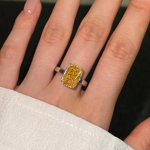 Macro detail of a silver ring featuring a large rectangular ice-cut yellow zircon stone