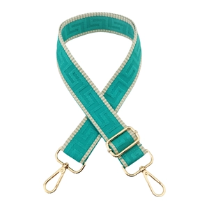 Detail of adjustable teal woven bag strap with Greek fret pattern and gold metal hardware