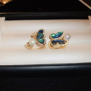 Detail of adjustable gold ring with abalone shell butterfly and freshwater pearl