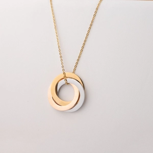 Detail of interlocking gold, silver, and rose gold rings on a fine golden chain necklace