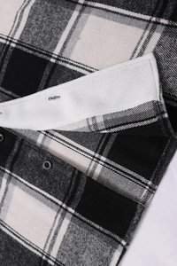 Detailed view of plaid shirt with warm white fleece lining and black buttons