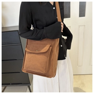 Brown corduroy shoulder bag detail with large front flap pocket and wide strap